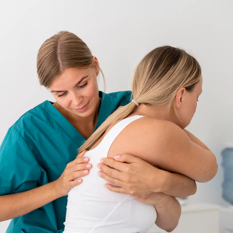Elena, la fisioterapista, accompagna il movimento della spalla di una paziente